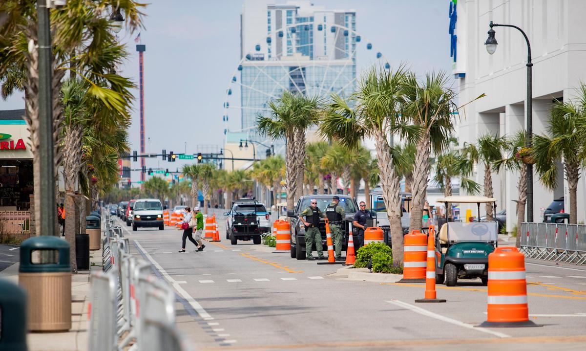 S.C. Department of Natural Resources officers chat along Ocean Boulevard in downtown Myrtle Beach Friday afternoon. Memorial Day weekend started off slow in Myrtle Beach as tourists trickled in. The crowds were significantly reduced with Black Bike Week canceled. City officials still expect a 75 to 100% occupancy rate.