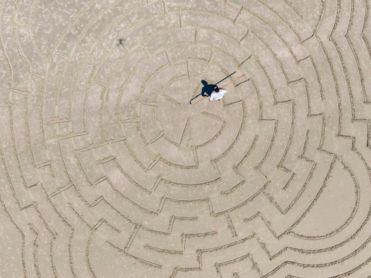 Hunter Gibbes, known locally as “Sunset Beach Maze Man,” has been making mazes at Sunset Beach, N.C. for nearly 20 years. The sand artist makes up the designs on the spot. Vacationers and locals rush to complete the mazes he creates before the tide comes in and creates a clean slate for his next artwork. Aug. 1, 2024.