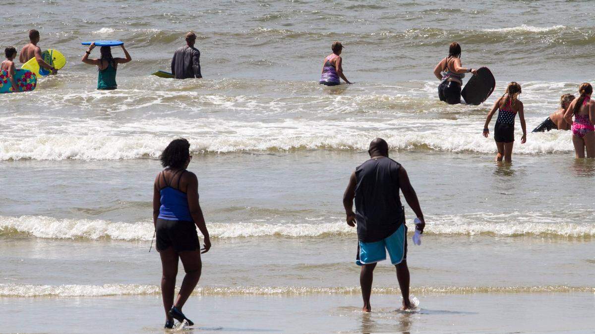 Swimmers re-enter the water in this Sun News file photo from 2016 a short time after reports of a possible shark bite in Horry County.