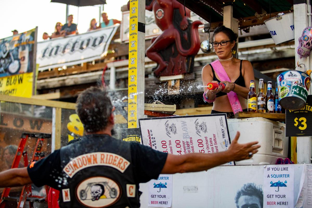 Bartender Kathleen Thompson of Denver, Co. squirts water on a customer at Suck Bang Blow Friday afternoon during Bike Week in Murrells Inlet.
