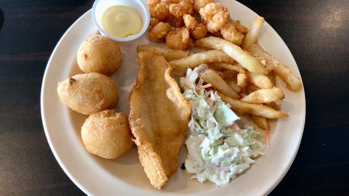 Popcorn shrimp, fries, coleslaw, fried flounder, hush puppies and honey butter at Captain Benjamin’s Calabash Seafood Buffet in Myrtle Beach, SC. Calabash-style fried fish can be found in North and South Carolina and beyond. July 28, 2023.