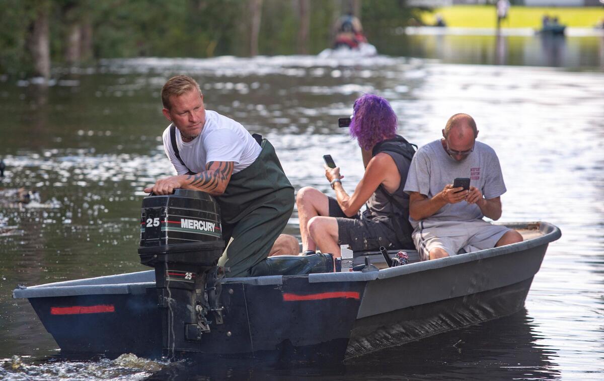 Peachtree Landing resident Greg Terry begins to shuttle three neighbors to their homes on Tuesday.  Terry has been transporting families back-and-forth in his boat throughout the weekend to retrieve personal belongings and to check on their homes.