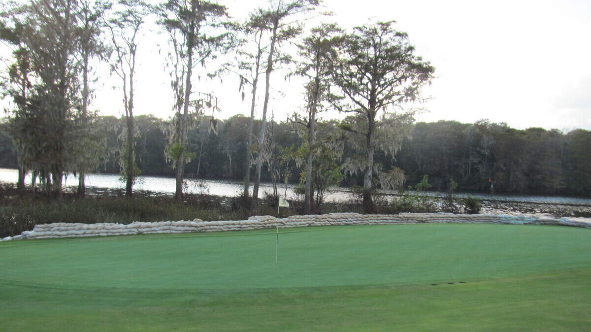 Sandbags line the side of the green of the par-5 18th hole at Wachesaw Plantation Club. The green abuts the Waccamaw River/Intracoastal Waterway.