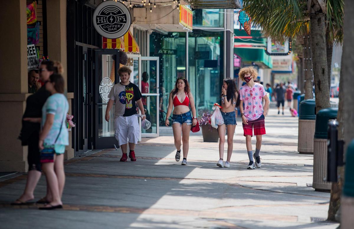 People walk along Ocean Boulevard in downtown Myrtle Beach Friday afternoon. Memorial Day weekend started off slow in Myrtle Beach as tourists trickled in. The crowds were significantly reduced with Black Bike Week canceled. City officials still expect a 75 to 100% occupancy rate.