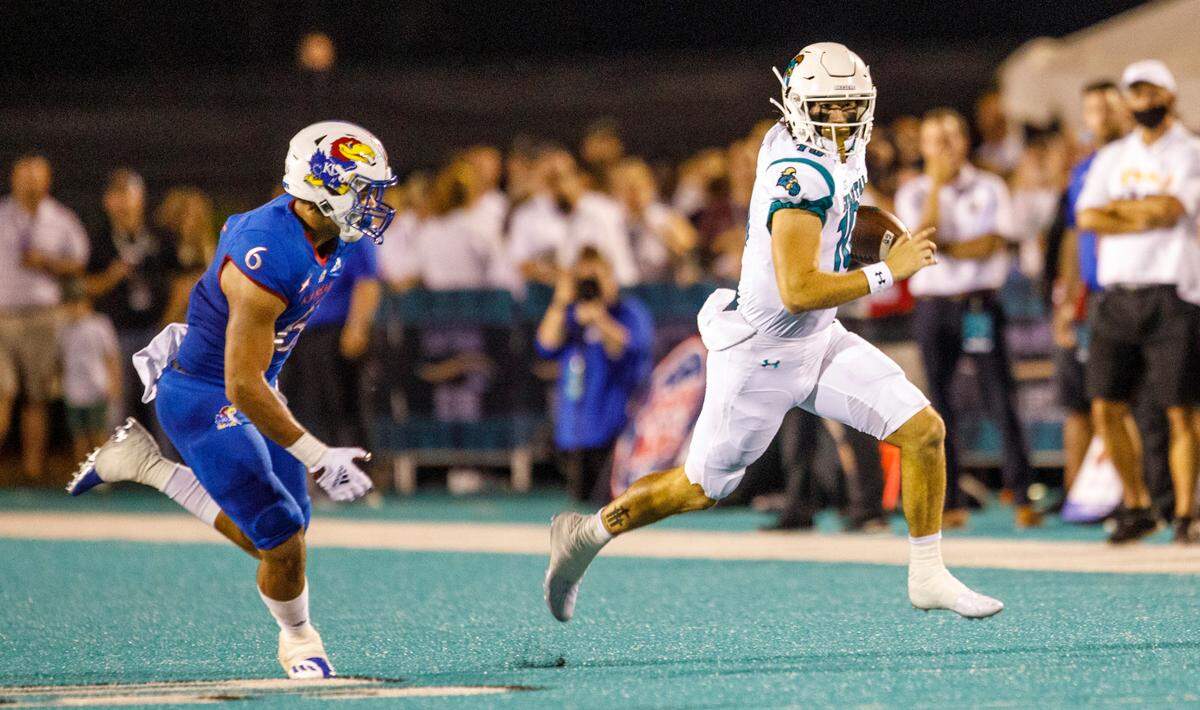 Coastal’s Grayson McCall keeps the ball to rush against Kansas. The Coastal Carolina Chanticleers hosted Kansas at Brooks Stadium Friday night. Aug. 11, 2021.