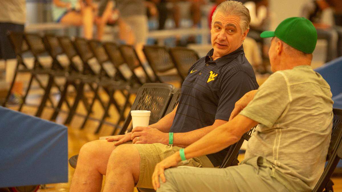 West Virginia assistant basketball coach Ron Everhart, facing, chats with former longertime Socastee High and current Marshall head basketball coach Dan D'Antoni during the Big Shots' showcase event Friday at the Myrtle Beach Sports Center.