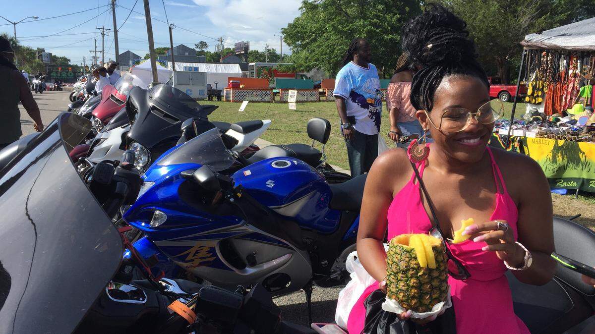 Courtney Nichols from Chicago enjoys one of the fruity drinks you can buy during Atlantic Beach Bikefest that’s poured into a hollowed out pineapple.