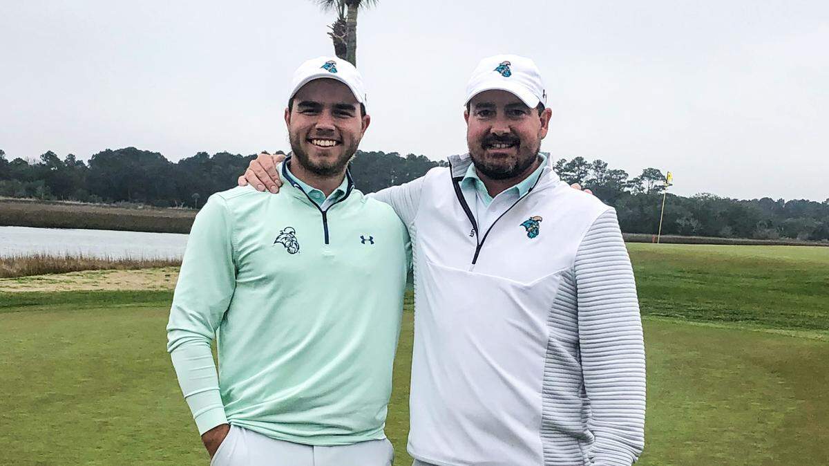 Coastal Carolina men’s golf coach Jim Garren (right) poses with States Fort in February 2021 after Fort won a tournament. Garren resigned on Thursday, according to the university.