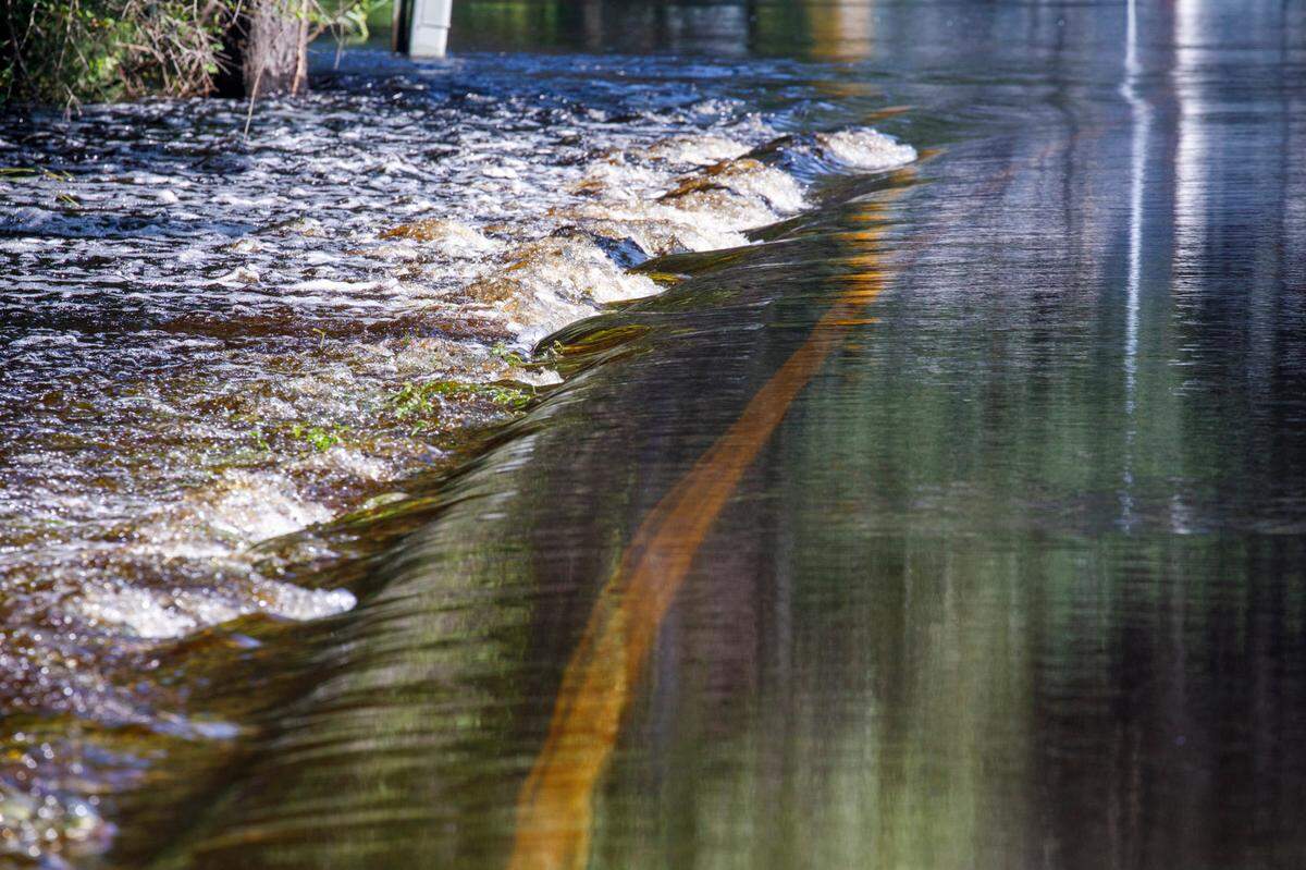 Flood waters flow over Lee’s Landing Circle Road near Conway on Friday. The Waccamaw River at Conway reached the major flood stage of over 14 feet on Friday following Tropical Storm Debby’s rains. The river is expected to crest this weekend. Aug. 16, 2024.
