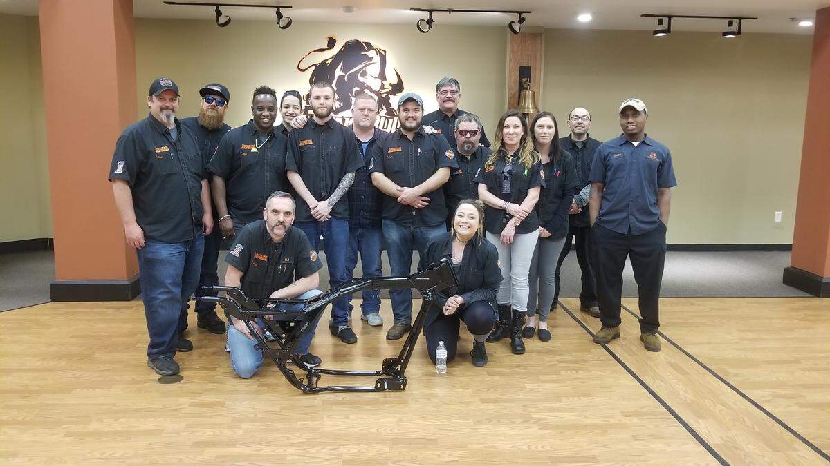 Members of Raging Bull Harley-Davidson in Durham, North Carolina stand with the frame of a motorcycle they are attempting to rebuild in honor of Sidney Williams, who died during the 2017 Myrtle Beach Fall Bike Rally