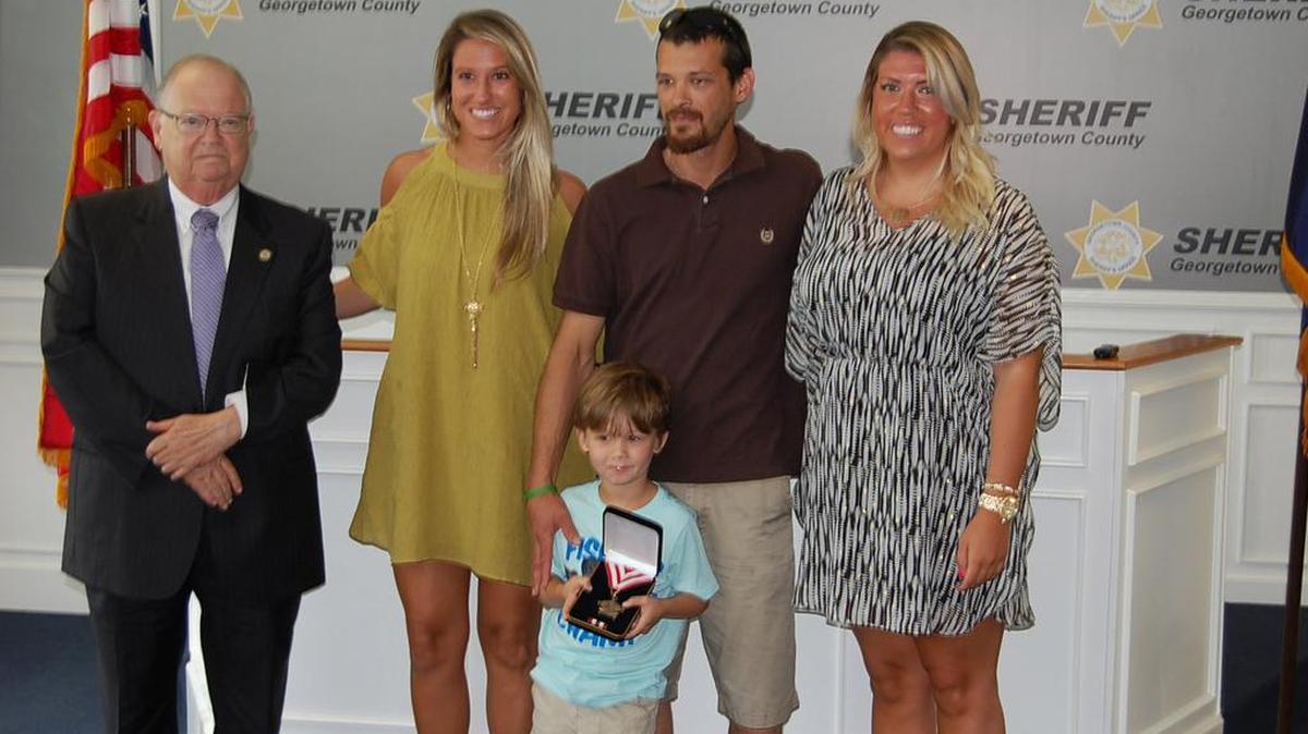 Georgetown County Sheriff Lane Cribb, left, presented the S.C. Sheriff's Association Lifesaving Award to D.J. Nance June 1. Cribb is standing with Haley Morris, Nance and his son, Dalton, and Kate Henry.