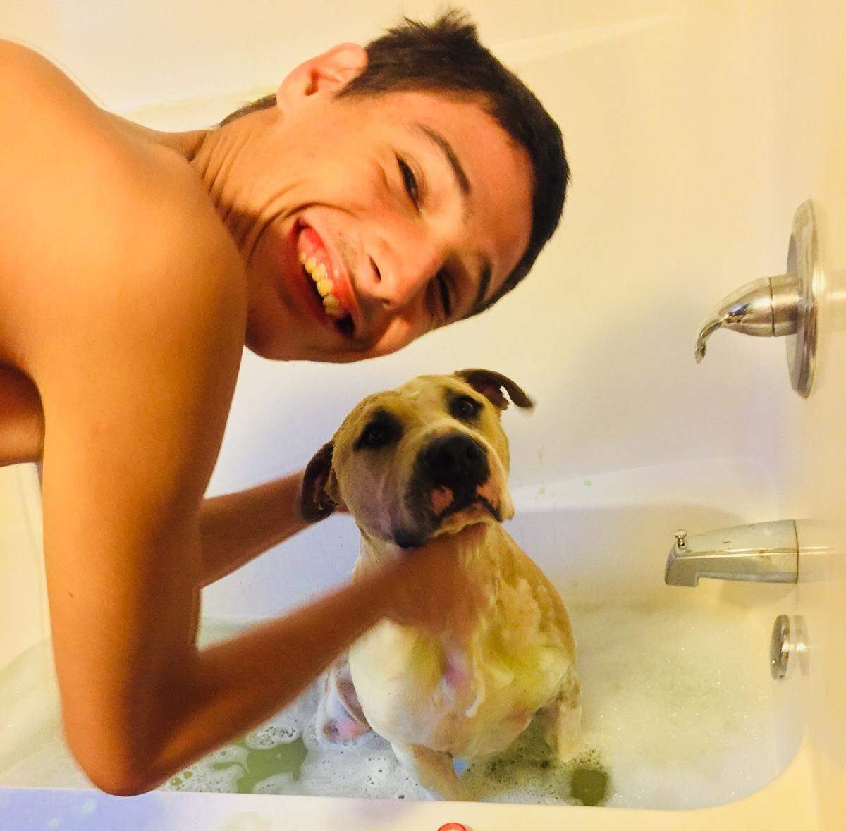 Dillan Bowman and his dog Chico. Dillan refuses to be separated from his dog, even as flood levels rise.