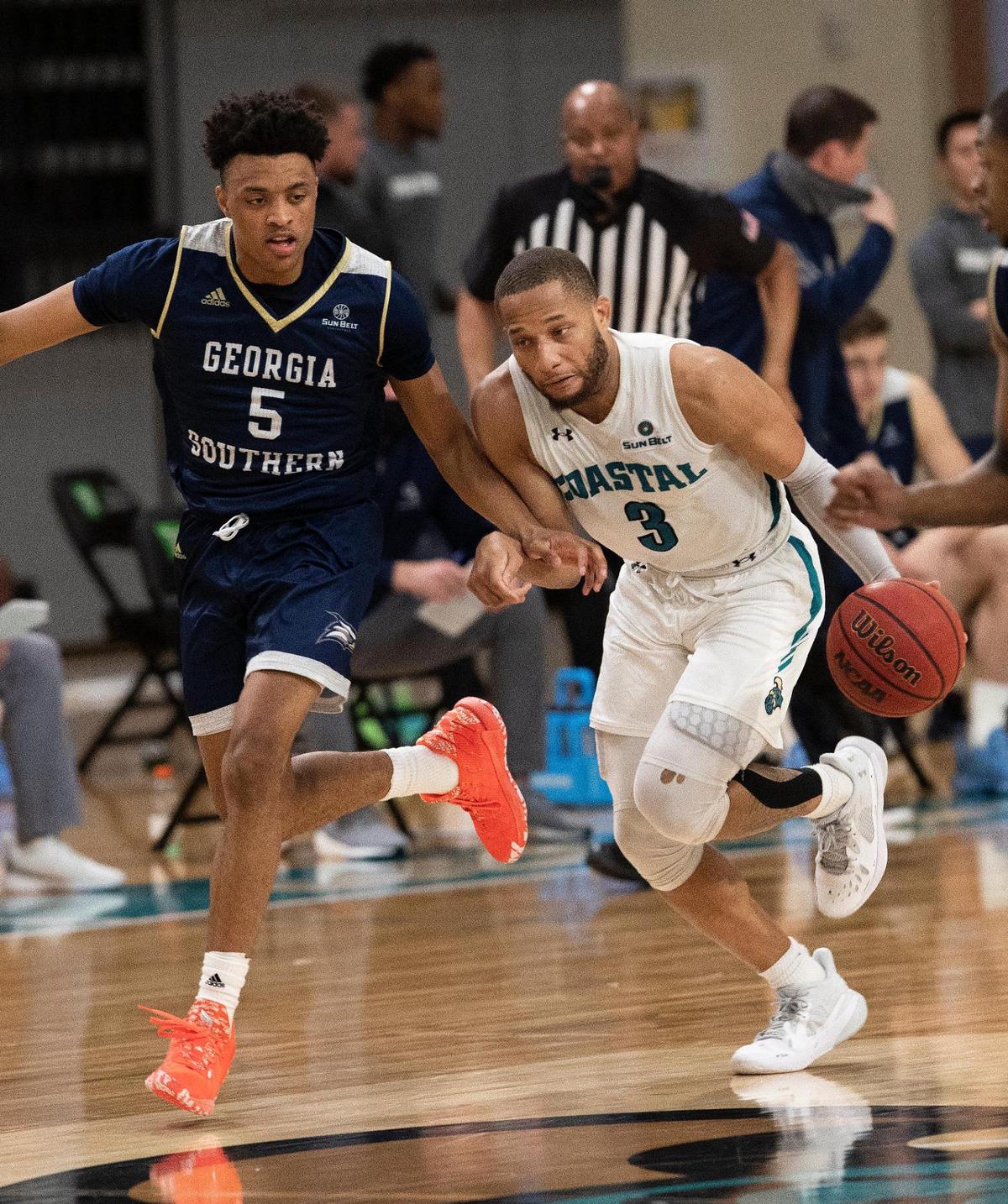 Coastal Carolina guard DeVante Jones (3) drives the ball past a full court press and Georgia Southern defender Eric Boone (5) on Sunday at the HTC Center in Conway.