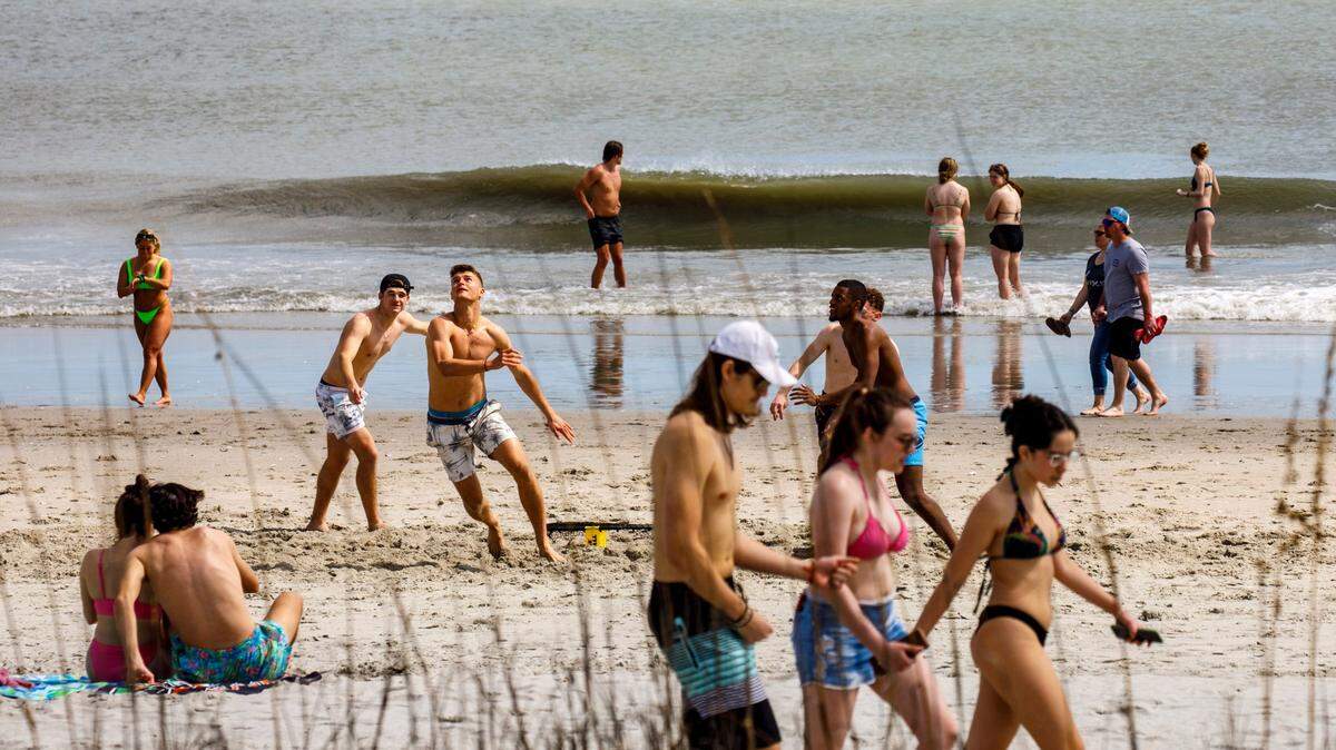 Students, most pictured from Rider University in New Jersey, play games and hang out on the beach in the downtown section of Myrtle Beach, S.C. Thousands of students visit the Grand Strand from late February to early April from Spring Break every year. March 17, 2022.