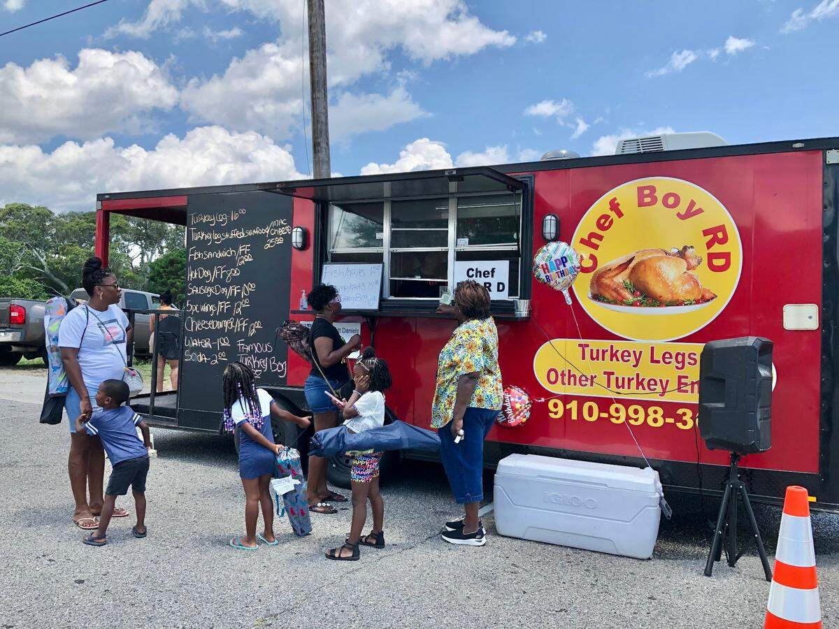 Families wait for food from Chef Boy RD’s food truck, based in Shallotte, N.C. Food vendors served up delicious flavors at the Atlantic Beach Gullah Geechee Festival. June 24, 2023.