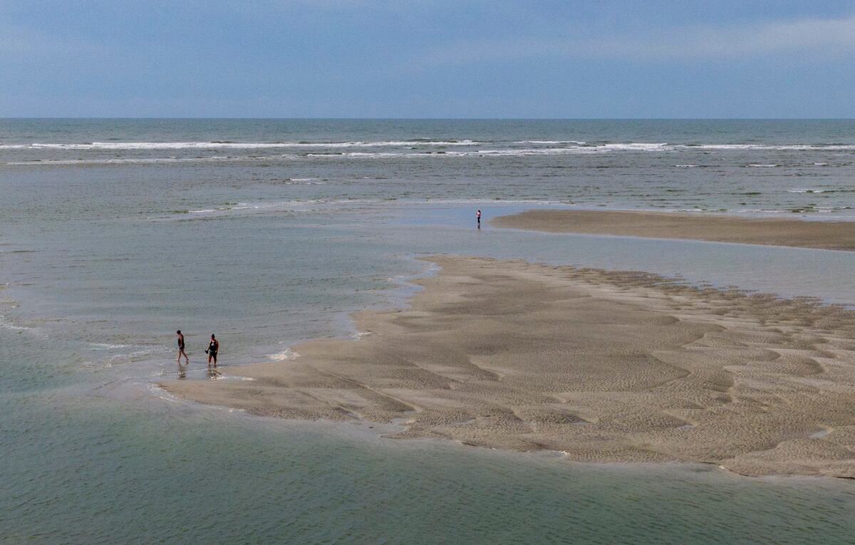 Beach goers enjoy the sand bars and tidal pools at the tip of Cherry Grove in North Myrtle Beach, S.C. The area, also known as Cherry Grove Point, has sand bars and tidal pools exposed during low tide. June 12, 2024.