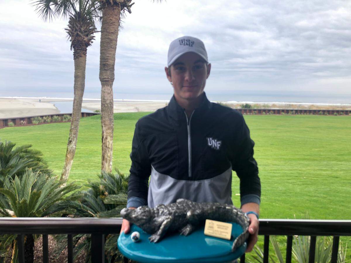 North Florida freshman Nick Gabrelcik holds the individual trophy after winning the 2021 V1 Sports General Hackler Championship at The Dunes Golf and Beach Club on Tuesday with an 11-under-par 205.