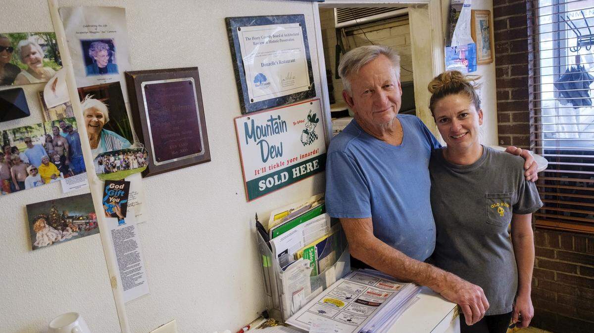Larry Dickerson with his daughter Marley Crotts, pose in the kitchen door during a break in service at Donzelle’s Restaurant. A favorite for more than 60 years, the eatery is known for both it’s comfort food and it’s social atmosphere. Founded by Donzelle and Dick Dickerson in 1962 and run by three generations of the family, Donzelle’s will close its doors on Christmas Eve. December 17, 2025.