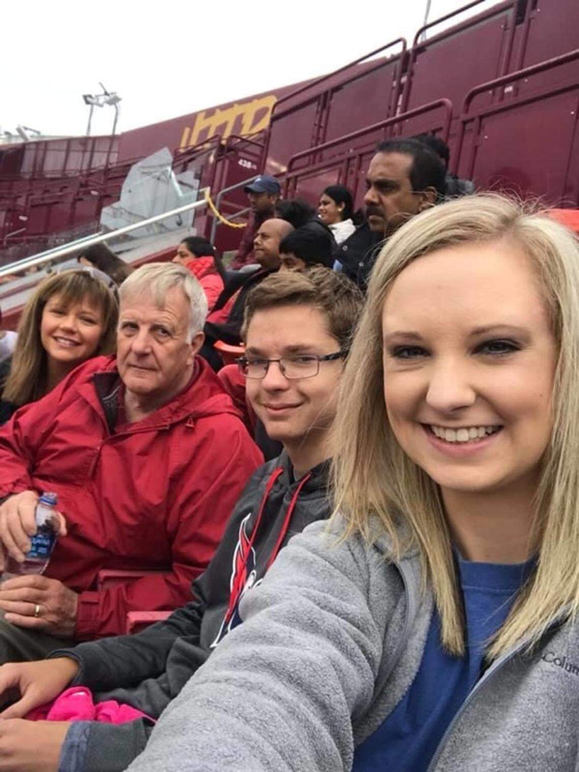 John Hicks takes a photo with two of his grandchildren at a Washington Redskins game. Hicks died on July 20 from coronavirus.