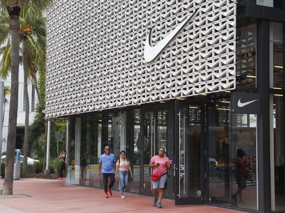 Shoppers walk past the Nike Miami store on the Lincoln Road Mall, Tuesday, Sept. 4, 2018, in Miami Beach, Fla. Nike’s stock was falling in early trading on Tuesday following an announcement that former San Francisco 49ers quarterback Colin Kaepernick has a new deal with the athletic clothing and footwear maker.
