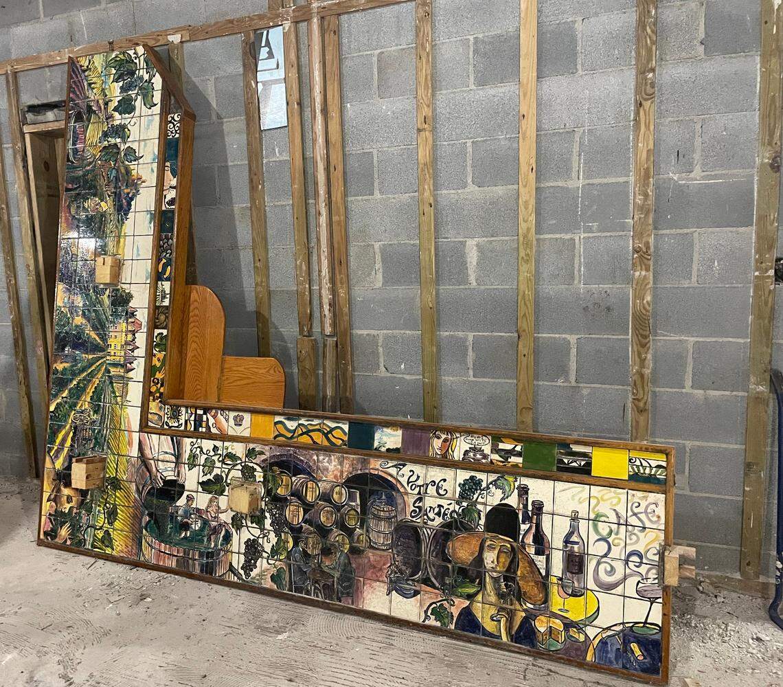 This painted tile countertop was created by artist Thomas Davis, the owner of Collector’s Cafe, a restaurant where the countertop once lived. The restaurant was damaged by a fire in 2020 and will now be rebuilt and Davis plans to incorporate this tile mosaic in his work. The piece, from top left to bottom right, shows the process of making wine.