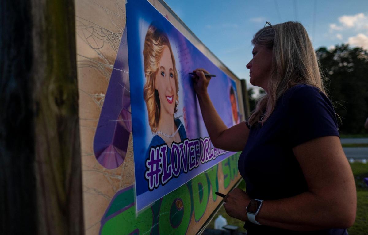 Kimberly Wall, mother of Laura Ashlee Anderson and wife of Nick Wall write on a banner at a vigil on Monday. The pair were shot and killed last week near Andrews, S.C. Ty Sheem Ha Sheem Walters III, 23, of Moncks Corner has been charged in their murders. August 31, 2020.