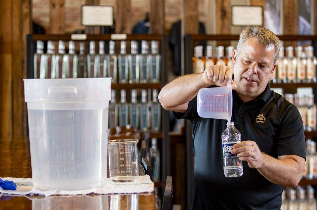Twelve 33 Distillery owner and head distiller Kevin Osborn pours a sample of his homemade hand sanitizer for a Little River resident Saturday morning at his distillery in Little River. Osborn began working on his mixture two weeks ago during bourbon production, taking two of the four hunded gallon fermenters that were filled with fermented bourbon mash and repurposing it, distilling it up to 191 proof before trying to source the other required ingredients based on the World Health Organization’s formula: pure ethyl alcohol, glycerin, water and hydrogen peroxide. The distillery will be giving away 4 oz. bottles of the sanitizer for free.