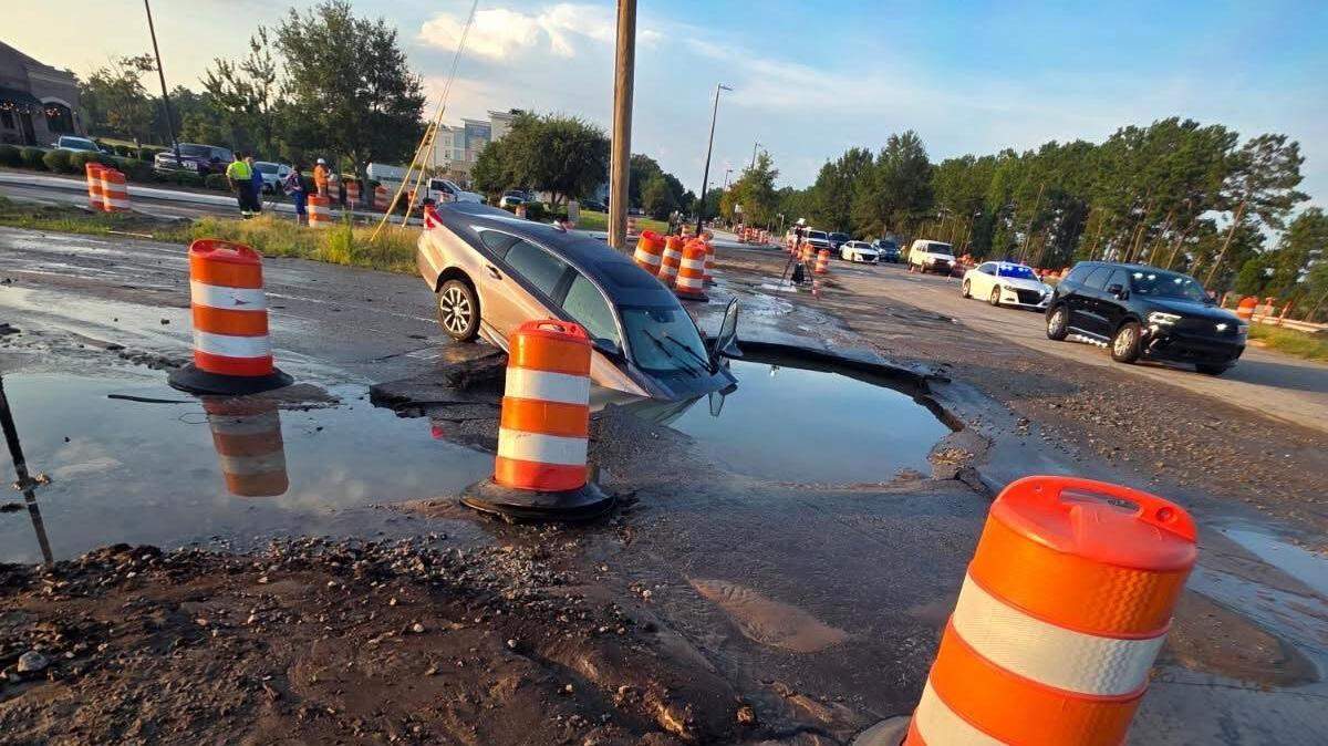 A water main break caused the road to collapse under a car in an intersection in Myrtle Beach.