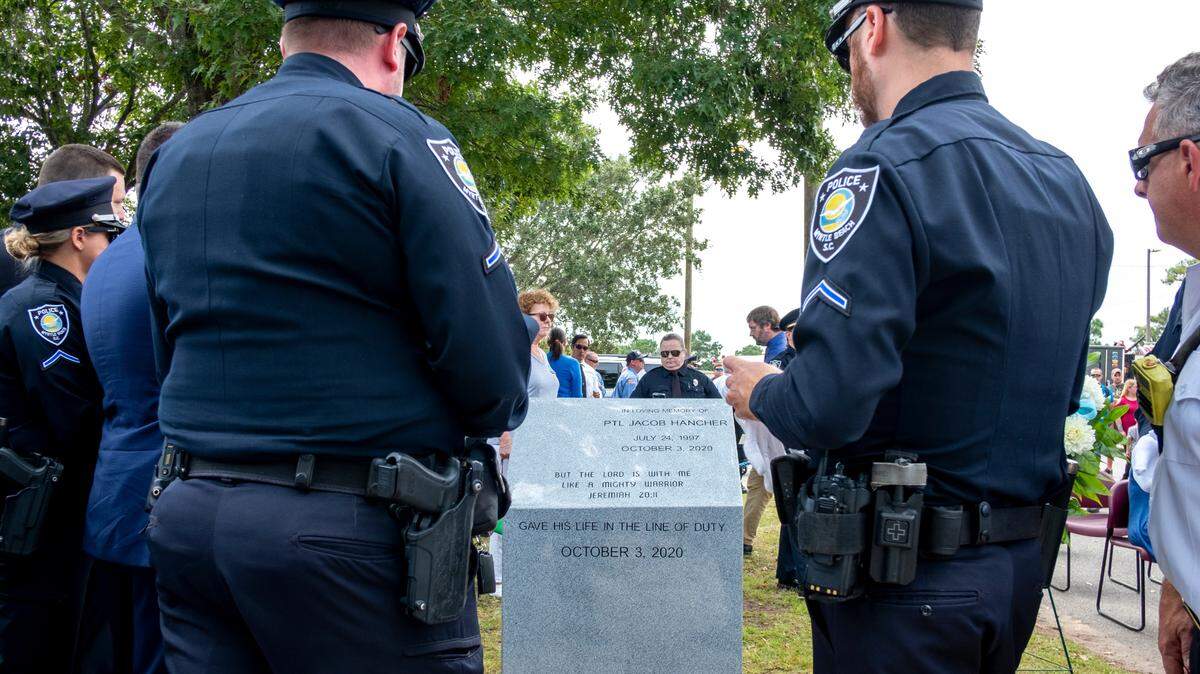 Myrtle Beach police officers look at the newly dedicated stone for former officer Jacob Hancher who died while on duty in 2020.