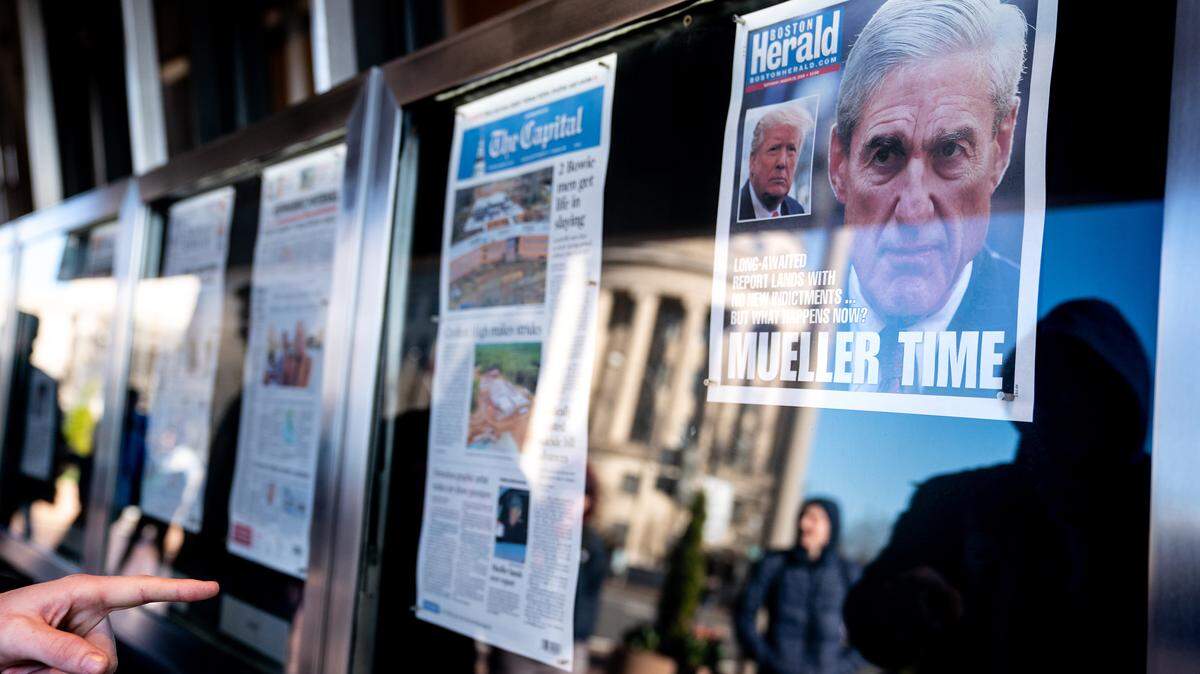 A person points at Saturday front pages of newspapers from across the country that announce Robert Mueller has finished his report, outside the Newseum in Washington, March 23, 2019. The special counsels work may be done, but prosecutors in Manhattan and elsewhere are pursuing investigations into the presidents family business and more. (Erin Schaff/The New York Times)