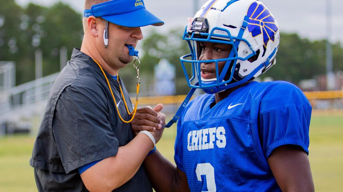 North Myrtle Beach Chiefs head coach Matt Reel greets his starting quarterback, senior Ramsey Lewis, during practice Tuesday afternoon in Little River.