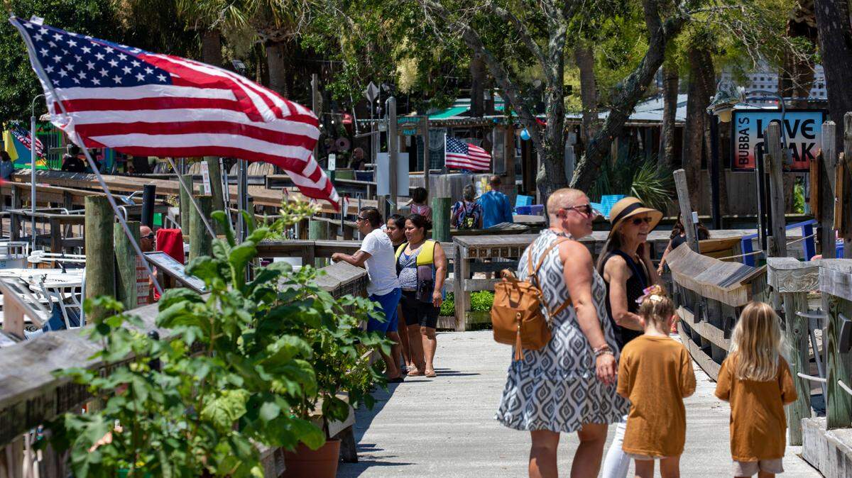 Visitors walk the Murrells Inlet Marshwalk. In the summer heat of July, Myrtle Beach area residents and tourist look to the water for relief. With waterparks, jet ski rentals, parasails, banana boat rides, paddle boards and kayaks, there are plenty of options to beat the heat. July 5, 2022.