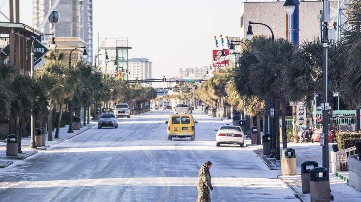 A pedestrian carefully crosses Ocean Boulevard in Myrtle Beach on Jan. 4, 2018 after Winter Storm Grayson.