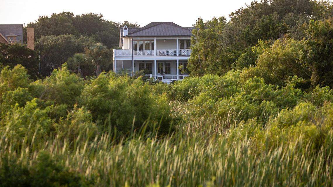 A house peaks through the trees of a maritime forest along the Sullivan’s Island shoreline.