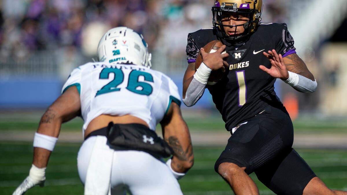 James Madison quarterback Todd Centeio (1) stares down Coastal Carolina safety Jairan Parker (26) during the first half of an NCAA college football game in Harrisonburg, Va., Saturday, Nov. 26, 2022. (Daniel Lin/Daily News-Record via AP)
