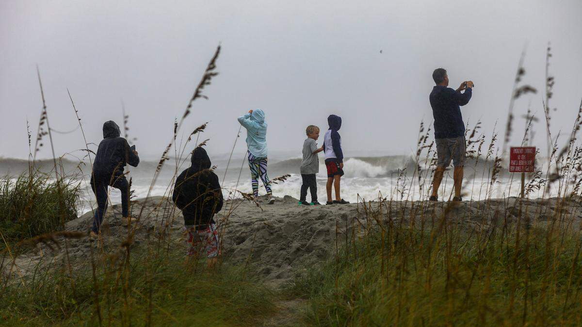 People cross a man made dune in North Myrtle Beach to look out to the sea as Hurricane Ian approached. September 30, 2022.