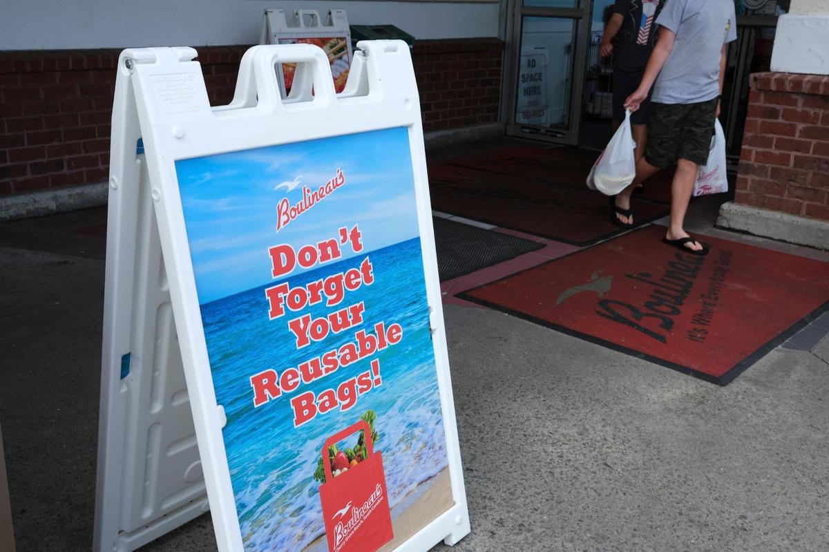 A sign in front of Boulineau’s Foods Plus in North Myrtle Beach, S.C. encourages customers to use reusable bags that they give away with every $100 purchase or may be purchased individually for $.99. The grocer is making a transition away from plastic bags to the more environmentally friendly paper and reusable tote bags but has struggled with the cost and supply of paper bags. The local grocery has given away over 100,000 reusable bags. July 6, 2022.