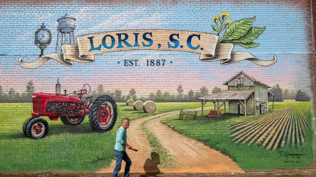 Tommy Simpson, a muralists, paints on the side of a building off Main Street in Loris, S.C. Simpson is known for his large nostalgic murals around the region. October 31, 2022.