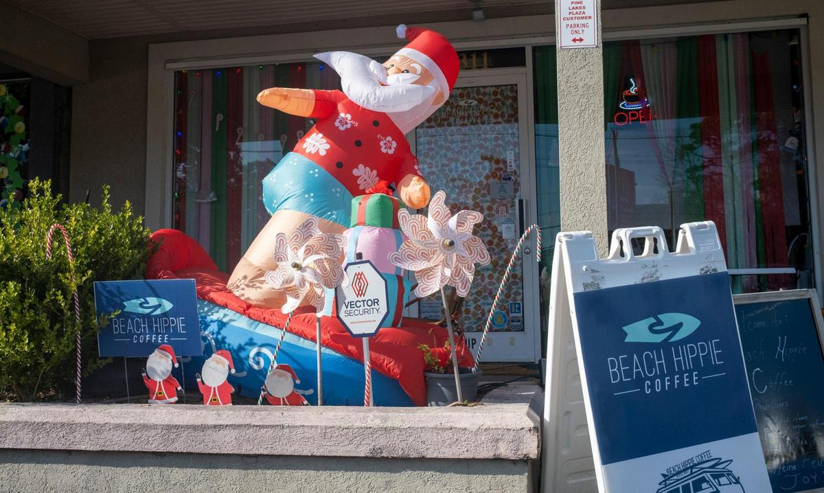 A Santa rides a surf board in front of Beach Hippie Coffee in Myrtle Beach. Many Myrtle Beach cafe’s are serving unique holiday flavors this season. December 7, 2022.