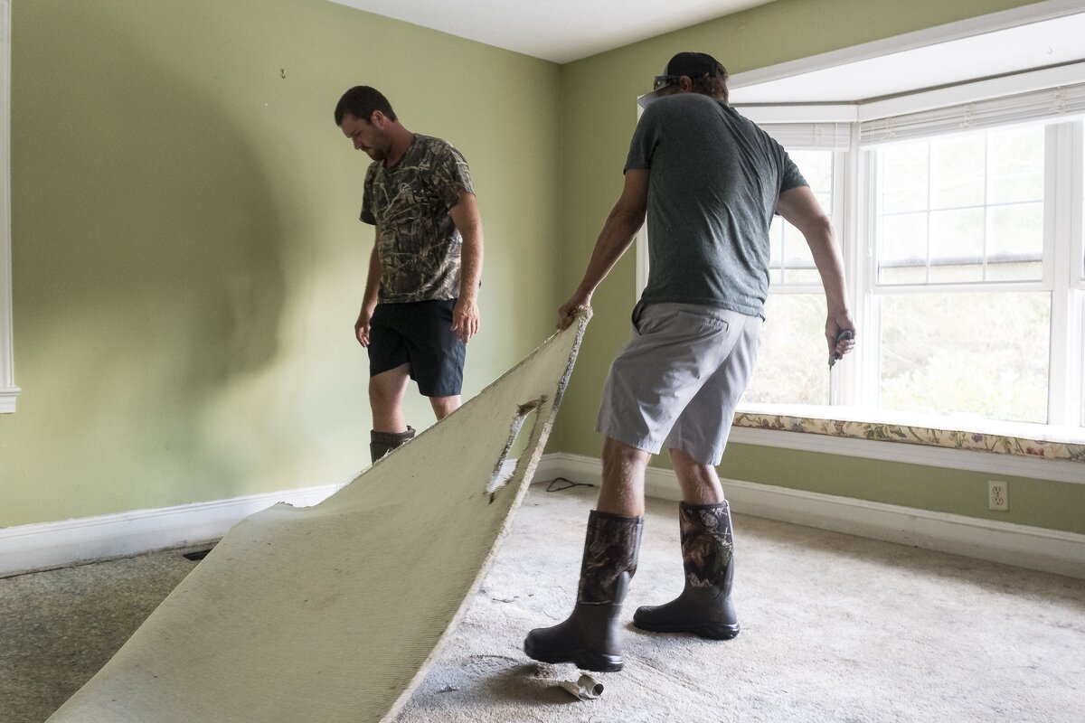 Jess White gets help from his friend Cody Squires pulling soaked carpets from his home on Busbee Street in Conway. Monday, October 1, 2018.