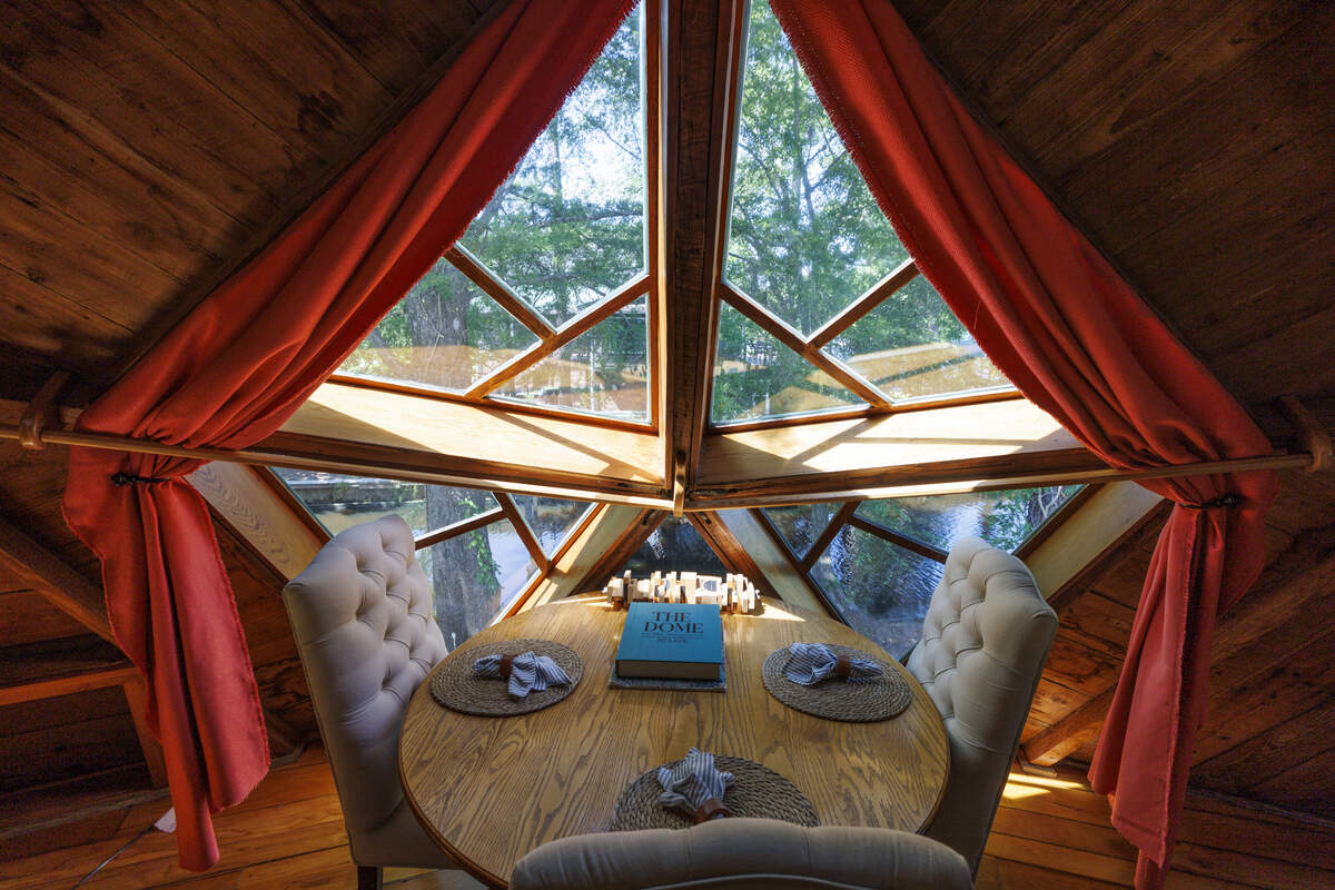 A table in an upstairs alcove features a book crafted about the history and construction of The Dome at Wild River. The unique 1970s home features custom woodworking and sits above the Waccamaw River outside of Conway, SC.  June 11, 2026.