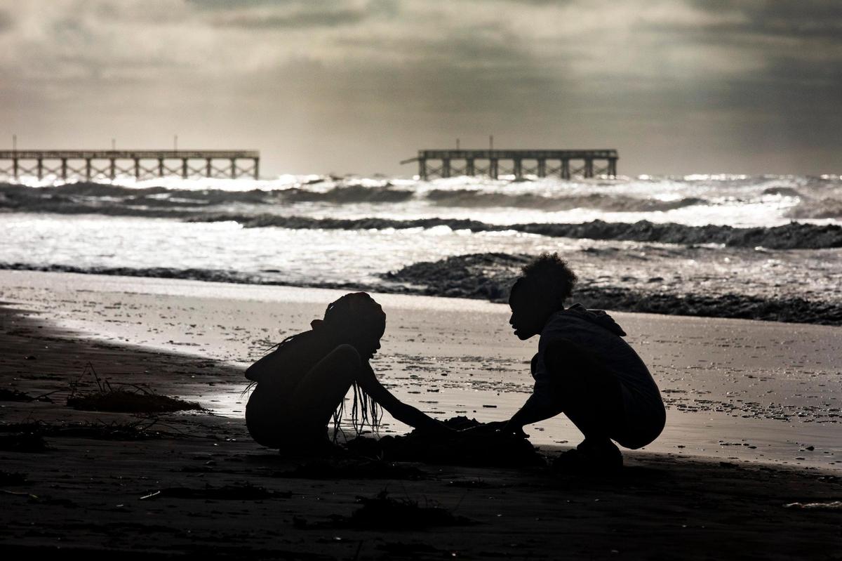 Children play on the beach near the storm damaged Sea Captains Pier on Tuesday after Hurricane Isaias passed. The storm surge from Hurricane Isaias combined with king tides damaged caused damage to the dunes in North Myrtle Beach and collapsed a section of the Sea Cabins Pier. August 4, 2020.