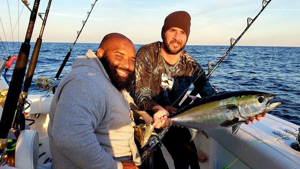 Terrance Dewitt (left) and Chance Martini show off a blackfin tuna caught while trolling offshore of Little River on Tuesday aboard Dirty Martini.