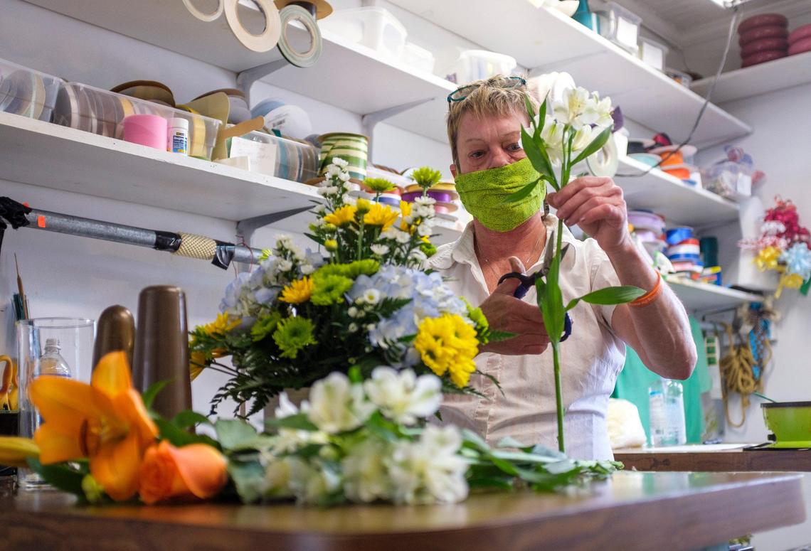 Wearing a mask, Jodie Wilson prepares fresh flower arrangements after Daisy Fair flowers in Conway re-opened this week. With Mother’s Day in just two weeks, florists are in a difficult position determining whether to open or remain closed during the coronavirus. April 23, 2020