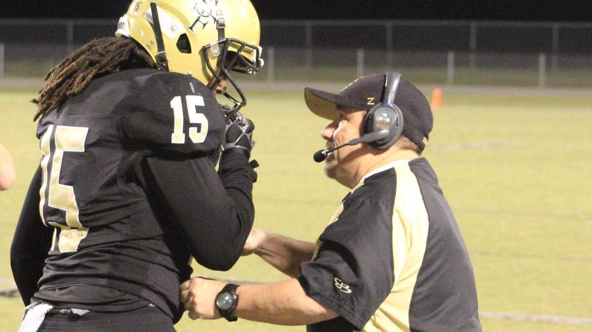 Green Sea Floyds coach Donnie Kiefer, right, goes over an offensive assignment with tight end Rashii Brisbon in the Trojans’ 68-0 victory over McBee on Friday.