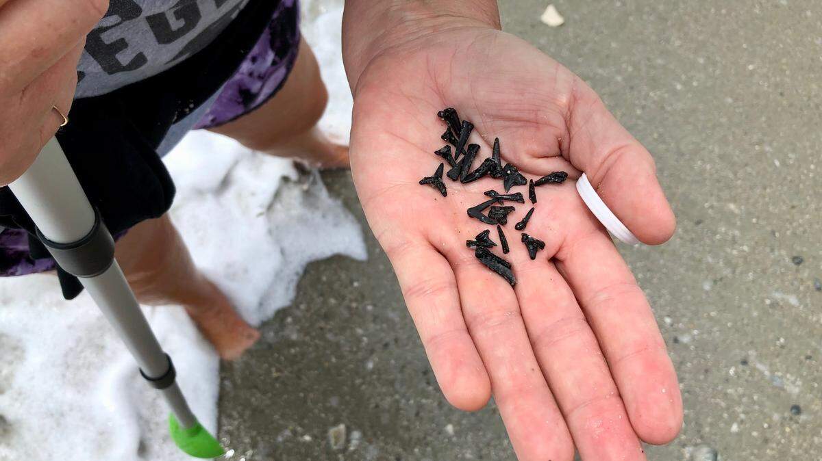Robin Smith of Carolina Forest shows off her shark teeth finds near the 20th Ave. S. beach access in Myrtle Beach. May 29, 2023.