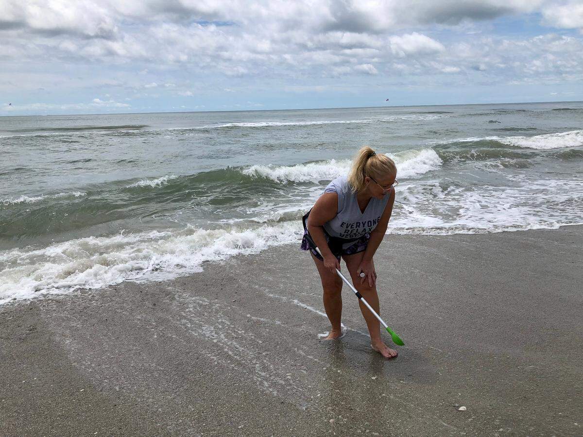 Robin Smith of Carolina Forest hunted for shark teeth near the 16th Avenue South beach access in Myrtle Beach on Memorial Day.