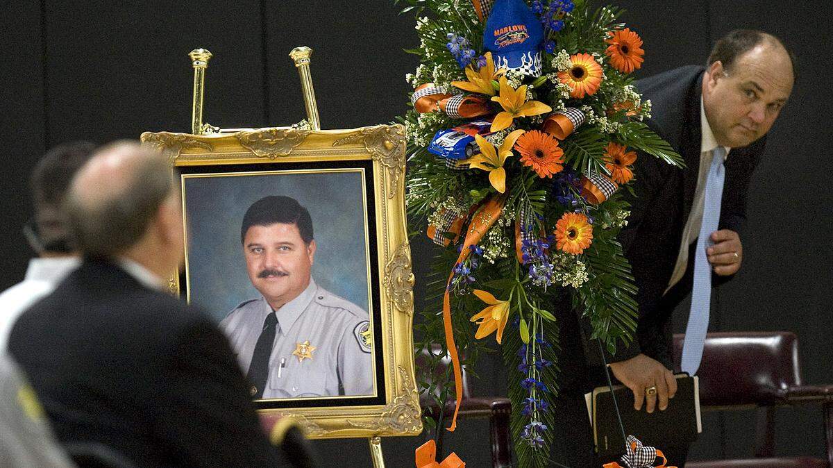 The Rev. Scottie Enzor looks around the flowers and photograph to let Horry County Sheriff Phillip Thompson know it is time for the eulogy at the funeral of Timothy Causey at Green Sea Floyds High School on Wednesday, May 22, 2013. Causey, 50, was a deputy with the Horry County Sheriff’s Office and died in May 2013. He was a law enforcement officer for 25 years in the area. Causey was hospitalized with severe smoke inhalation and acute respiratory failure after several nights working the Windsor Green fire site in the Carolina Forest community.
