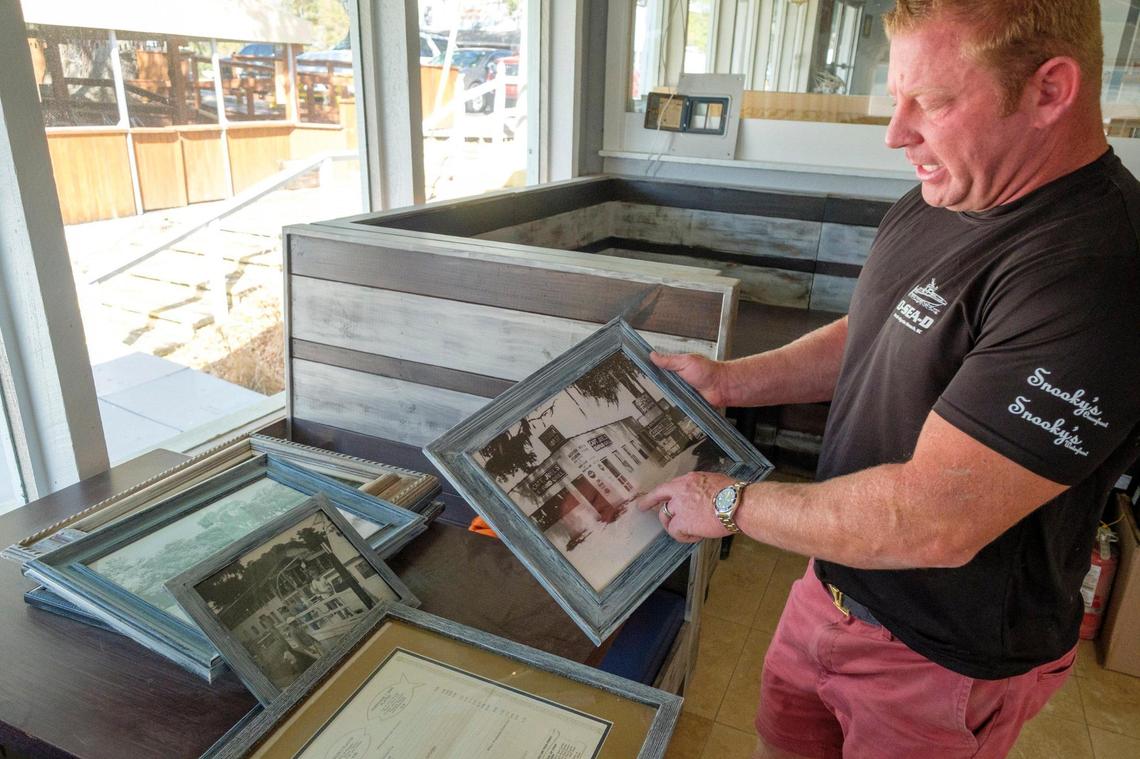 Lance Denny, the new owner of Hurricane Juel’s, points out historic photographs of the Little River waterfront that will remain on display in the restaurant. April 08, 2022.