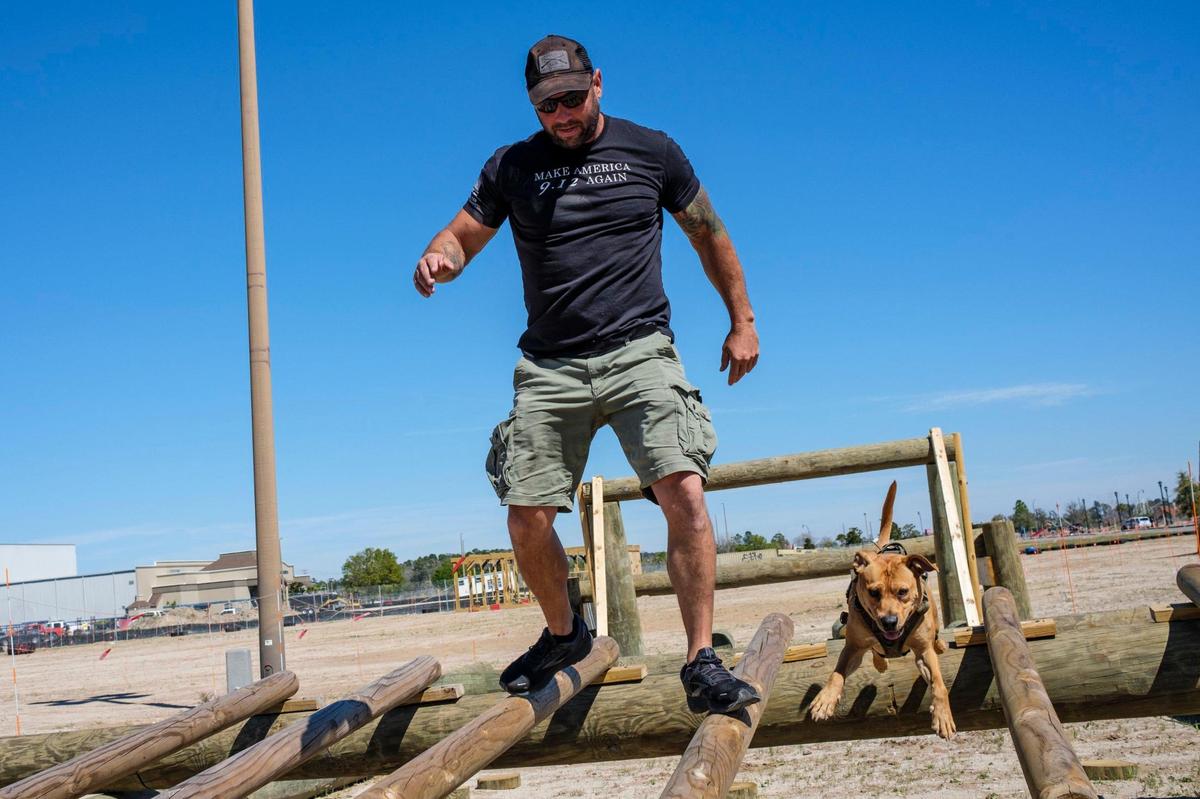 Ryan Small, owner of Beast Ninja Gym, along with his dog “Gunner” demonstrate some of the 30 obstacles he’s built for the Myrtle Beast All Terrain Race planned for May 21, 2022. The three-mile course with obstacles and physical challenges is being built on the site of the former Hard Rock Park off George Bishop Parkway. March 14, 2022.